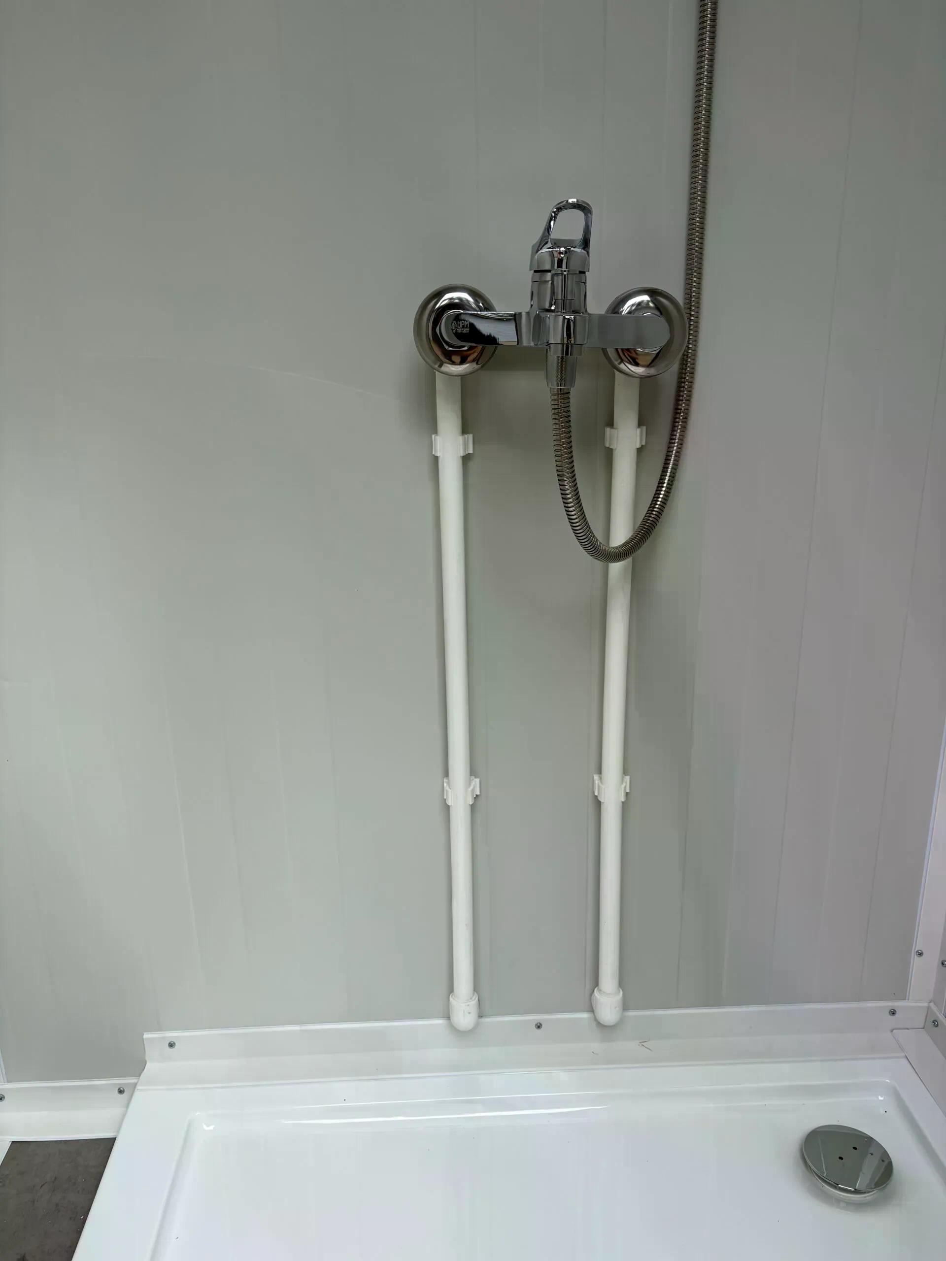 Mixer tap inside a dual portable shower unit.