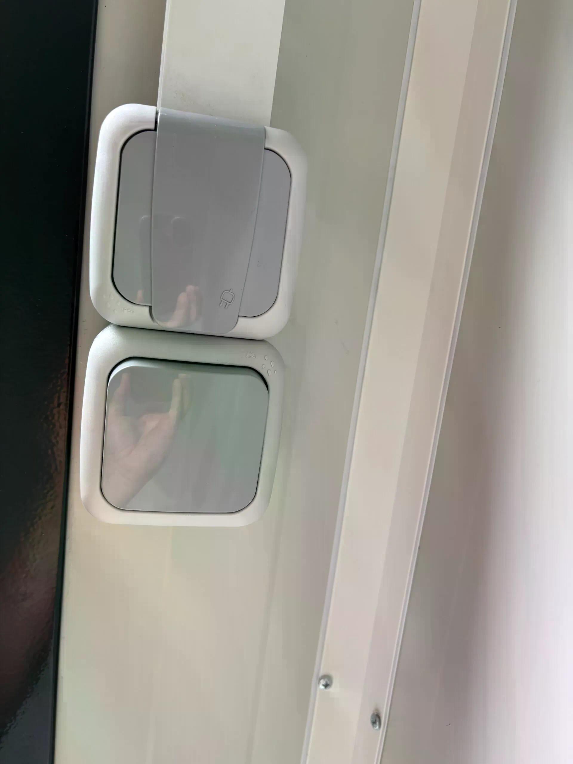 Dual portable shower unit with socket and light switch.