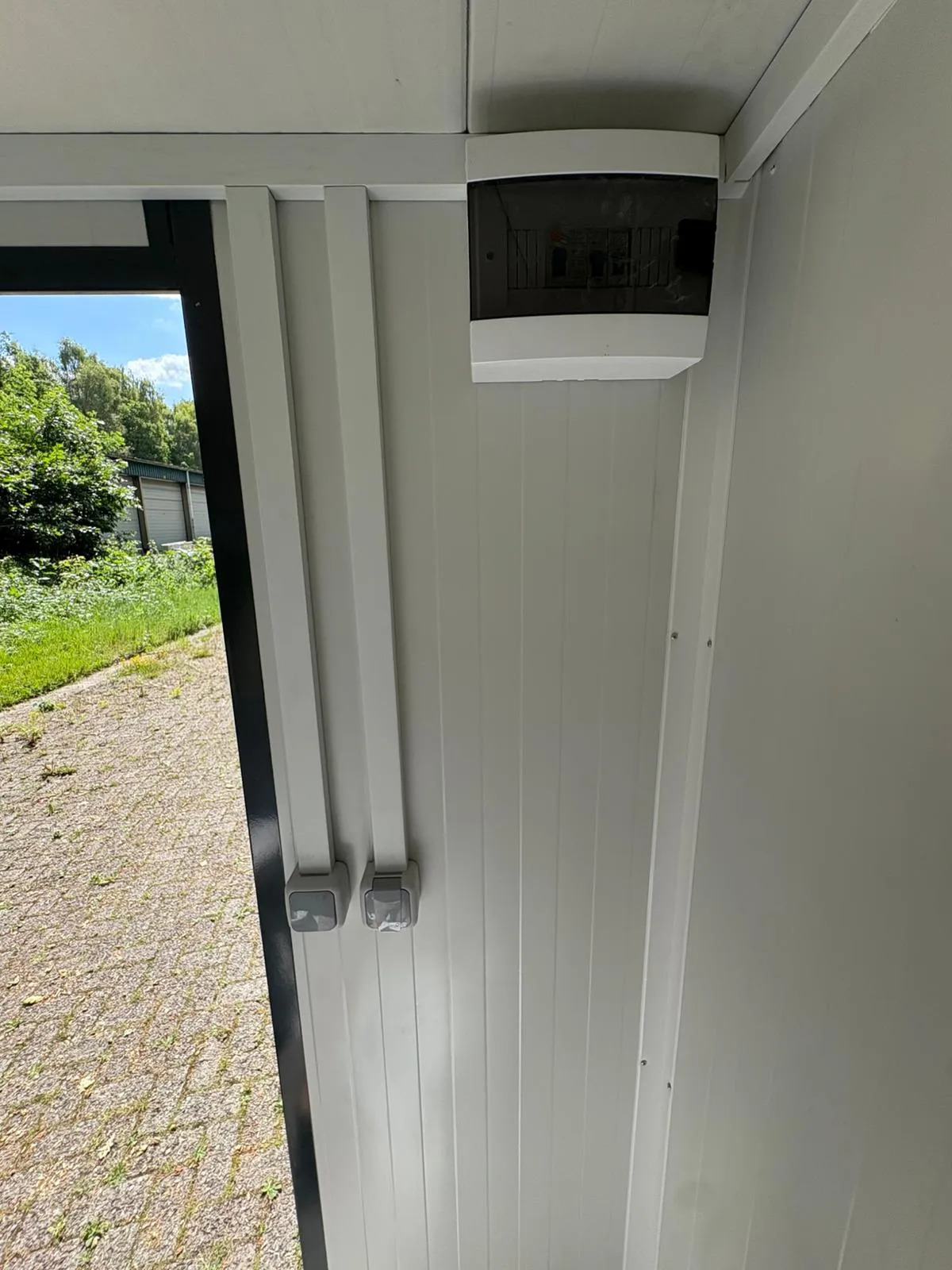 Fuse box and light switch inside a portable bathroom unit.