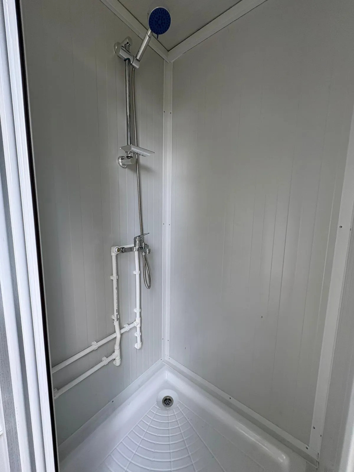 Shower set inside a portable bathroom unit.