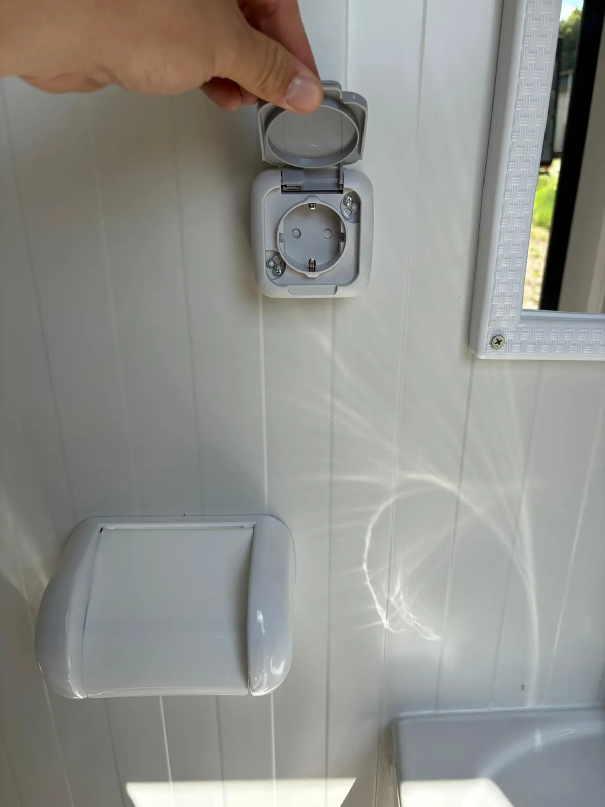 Electrical socket inside a portable bathroom unit.