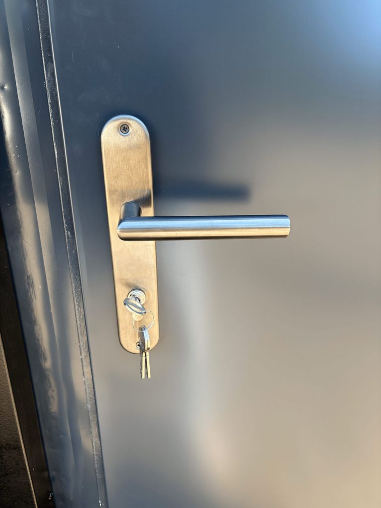Fuse box and door handle inside a portable toilet unit for camping.