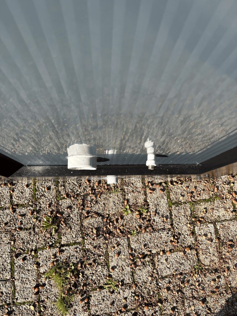 Top view of sewer and water connections on a portable toilet unit for camping.