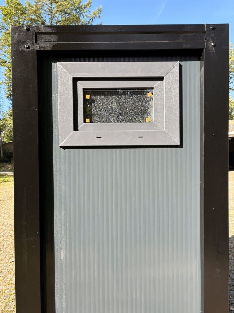 Exterior view of a portable toilet unit for camping with the window closed.